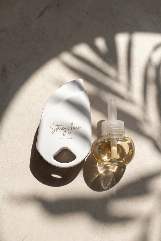 Stacey Jane 24/7 Lux Diffuser with sleek white design and textured ceramic base, emitting a soothing mist.