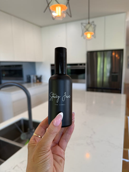Stacey Jane Sun Kissed Fragrance Spray in Brazilian Bum Bum scent, featuring a sleek bottle and sprayer for fresh, tropical aroma.